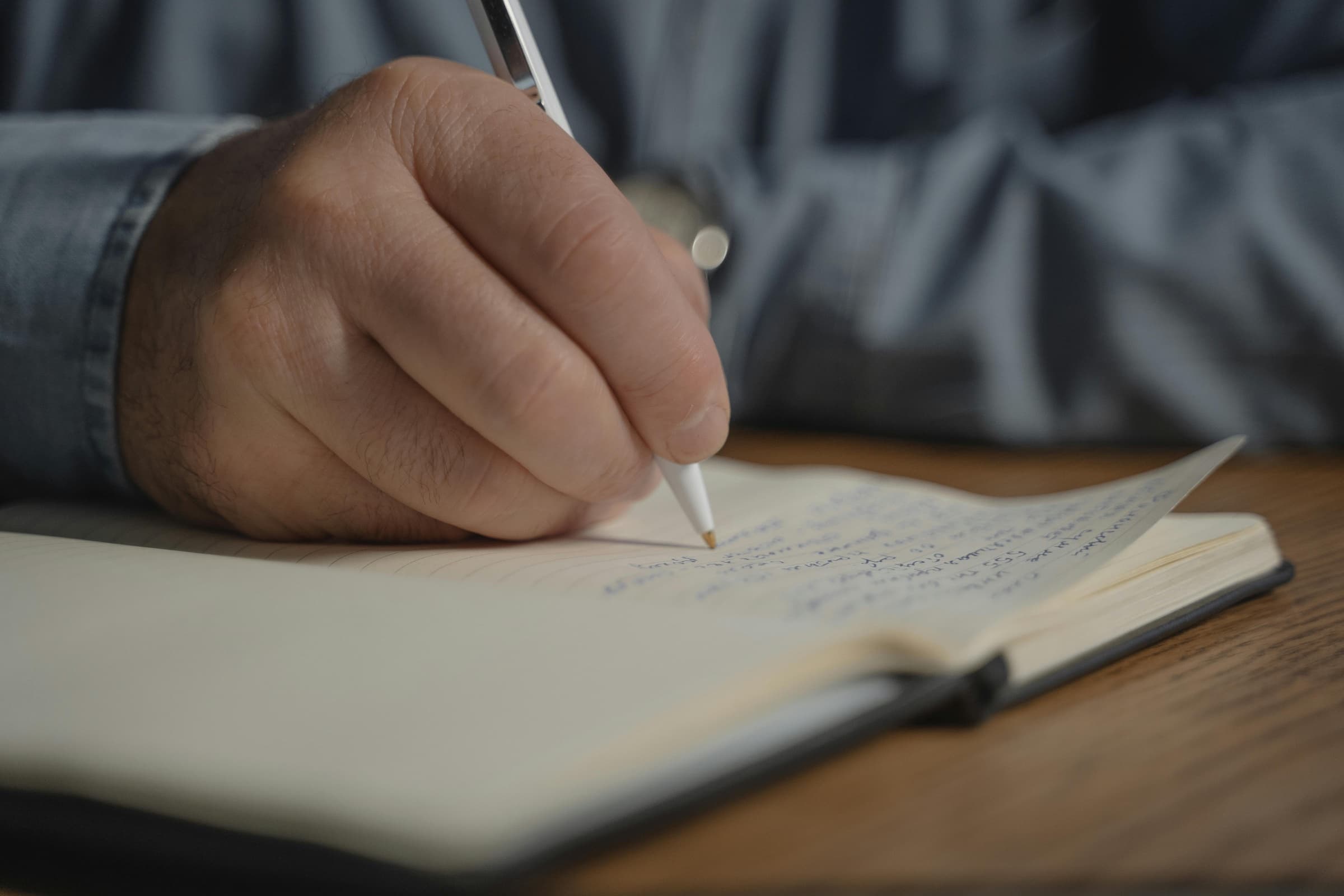 Hands writing in a notebook